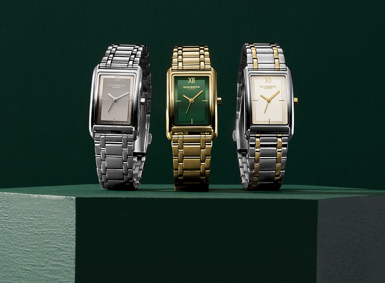 3 rectangle watches sat on a green block with green background