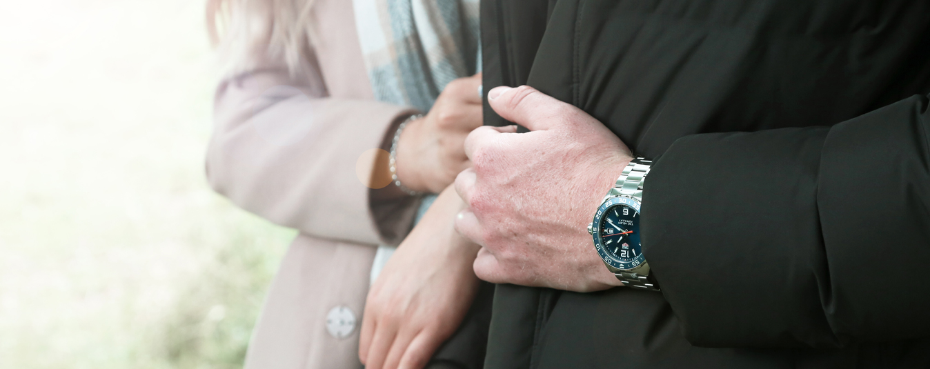 Close up of couple wearing coats and watches and jewellery 