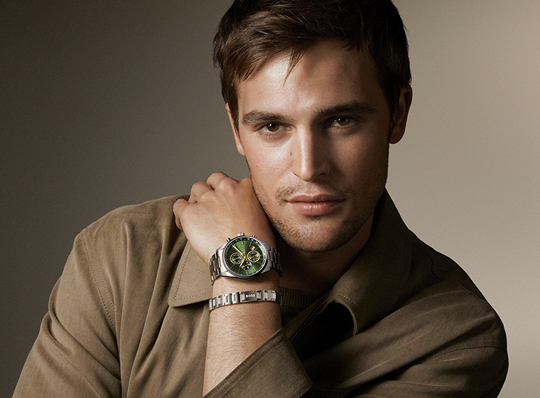 Man in a black jumper with dark hair and beard wearing a silver watch with a blue dial watch and steel bracelets  