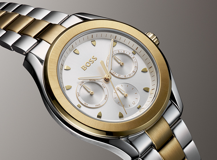 BOSS silver and gold tone watch with a silver dial on a brown faded background 