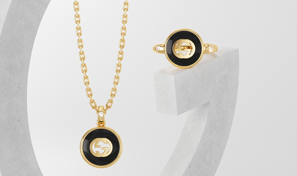 Gucci Gold Jewellery and Earrings on a grey background