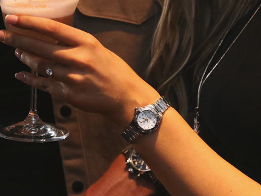 A close up of a TAG Heuer Watch on a ladies watch whilst hanging a bauble on a tree