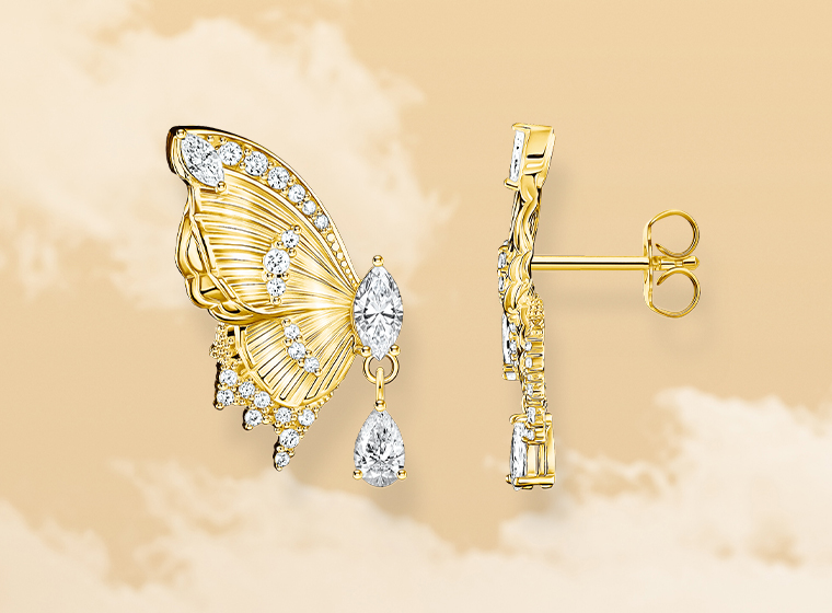 Gold earings with white stones, each represent half a butterfly