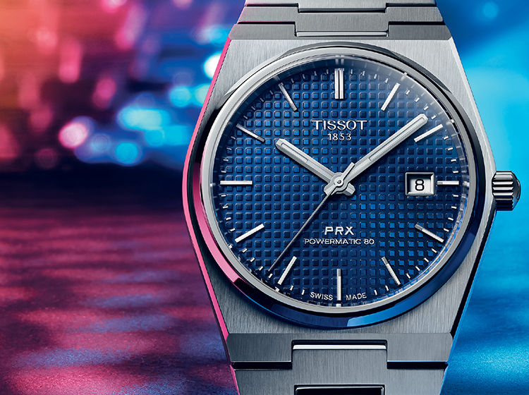 Tissot blue dial PRX steel watch on colourful background